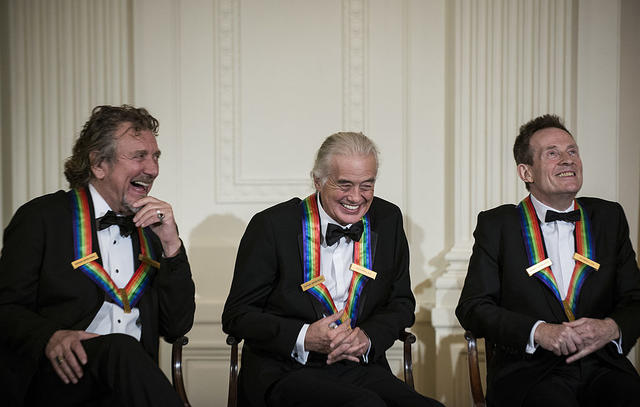 (L-R) Led Zeppelin band members Robert Plant, Jimmy Page, John Paul Jones listen during an event in the East Room of the White House December 2, 2012 in Washington, DC. US President Barack Obama and First Lady Michelle Obama attended the event at the White House with the 2012 Kennedy Center Honorees to celebrate their contribution to the arts before heading to the Kennedy Center for the honors program. AFP PHOTO/Brendan SMIALOWSKI (Photo credit should read BRENDAN SMIALOWSKI/AFP via Getty Images)